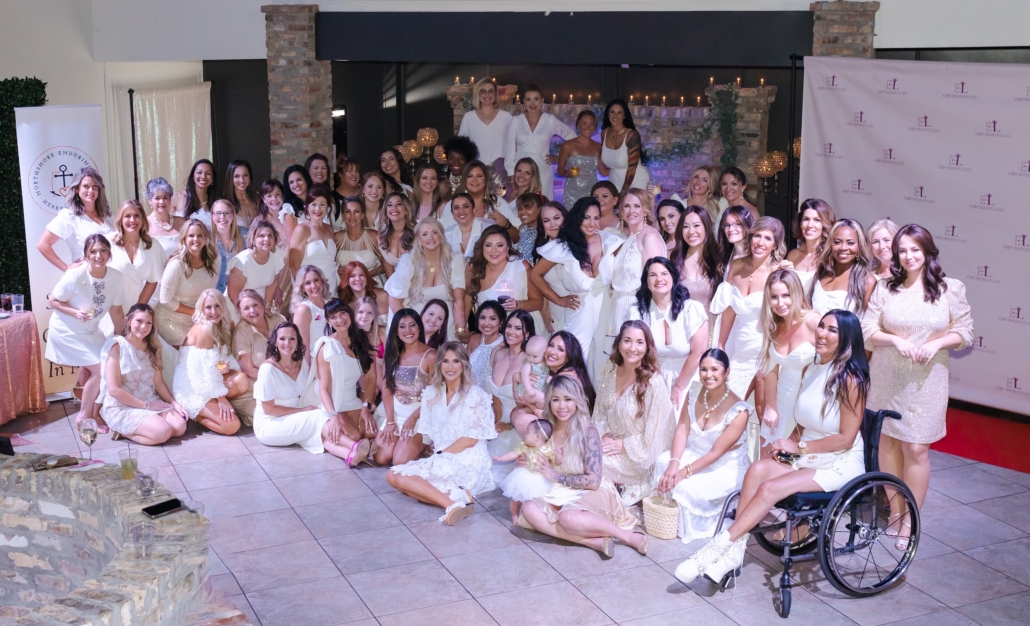 EmpowerHer Life members gather for a group photo, dressed in white to celebrate the first year anniversary of the organization